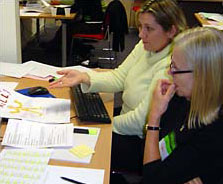 Picture of teachers sitting in front of a computer xsrc=